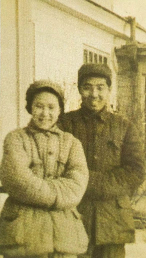 photograph of a smiling man and woman wearing heavy coats and hats