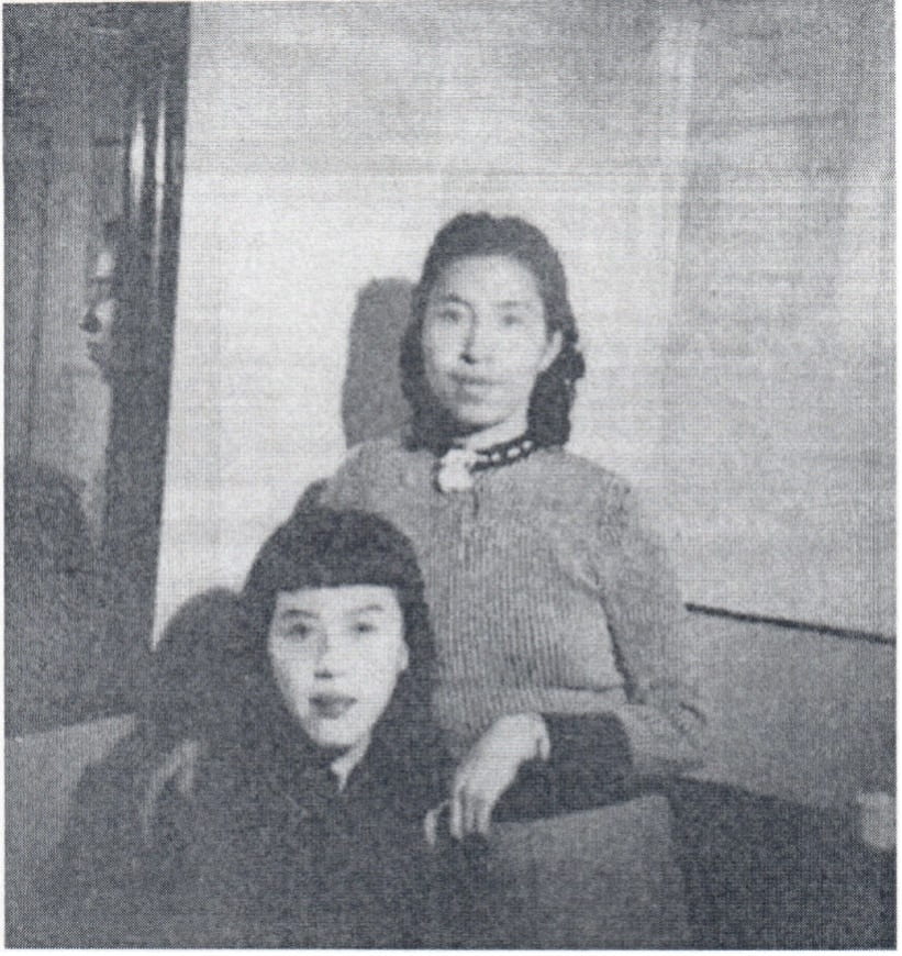 black and white image of tow young women posing together for a photo