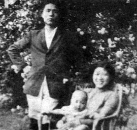 Luo Feng stands beside his wife, bai Lang, who is seated holding their child