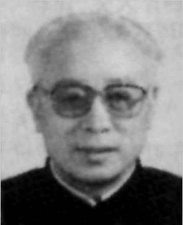 A blurry portrait of an elderly man with glasses