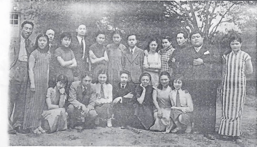Black and white photograph of a group of men and women posing for a photo