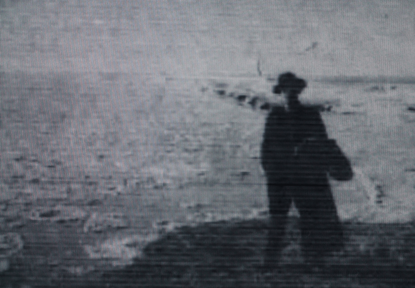 blurry black and white photograph of a man standing outside