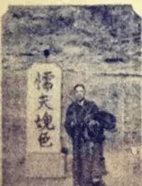 blurry image of a man standing beside what appears to be work of calligraphy