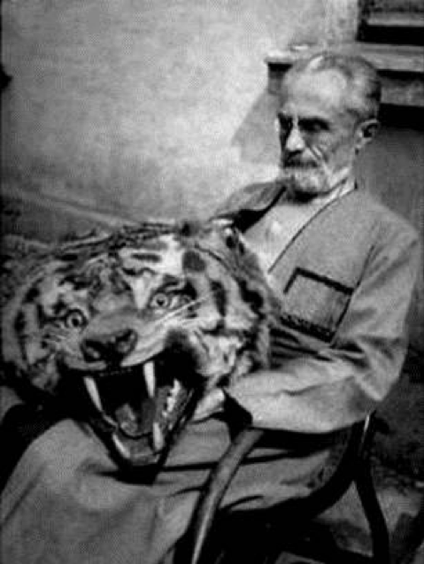 black and white photograph of an elderly man with a taxidermy tiger