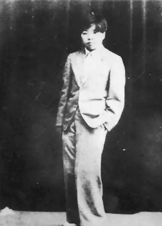 black and white photograph of a young Xiao Hong standing