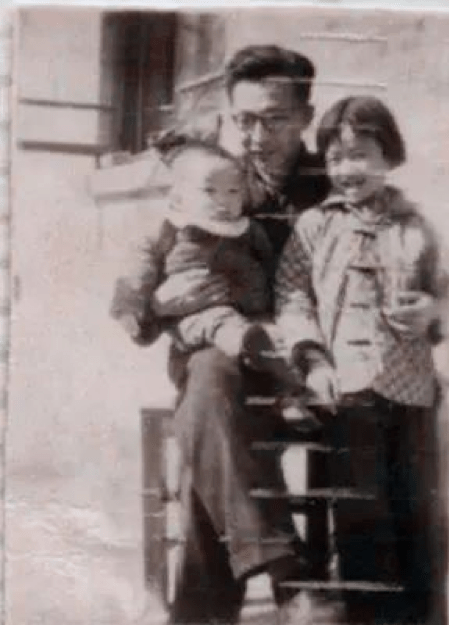 black and white photograph of Yuan Xi sitting down and holding his son and daughter