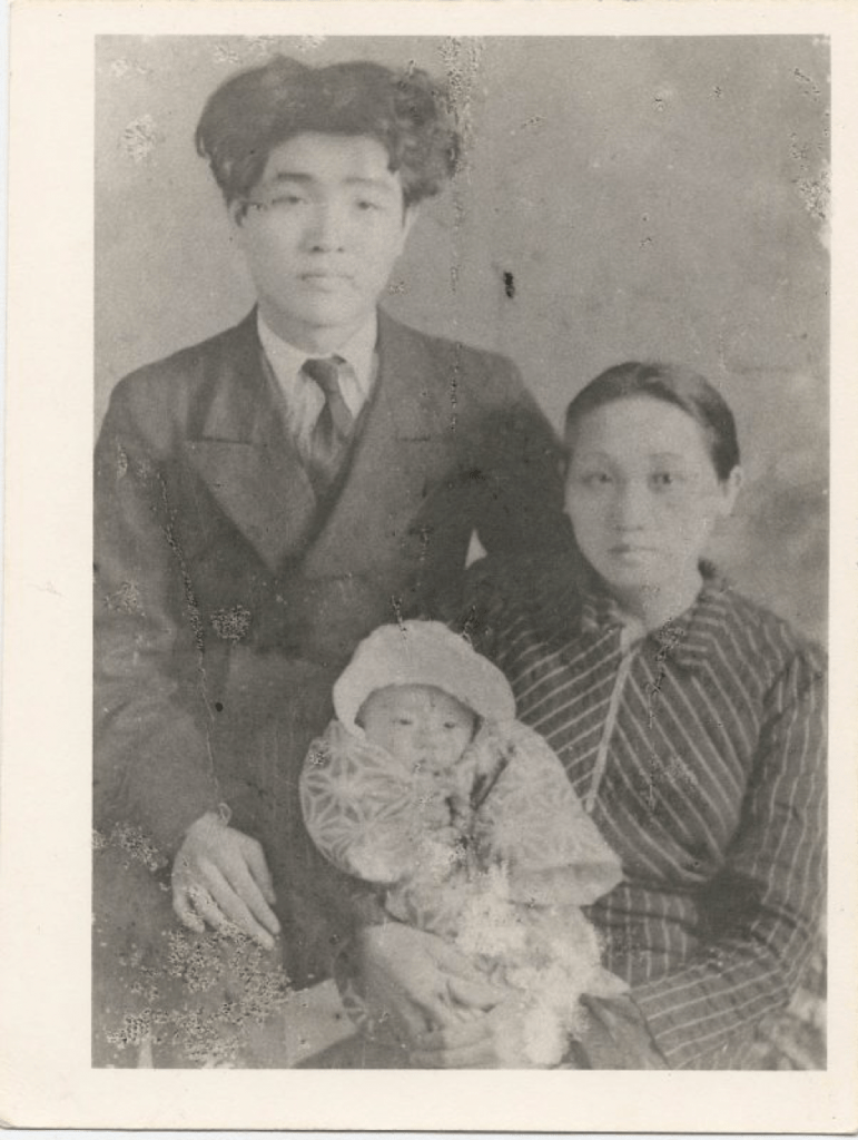 black and white photograph of Zhong Lihe, and Zhong Taimei holding their child Zhong Tiemin