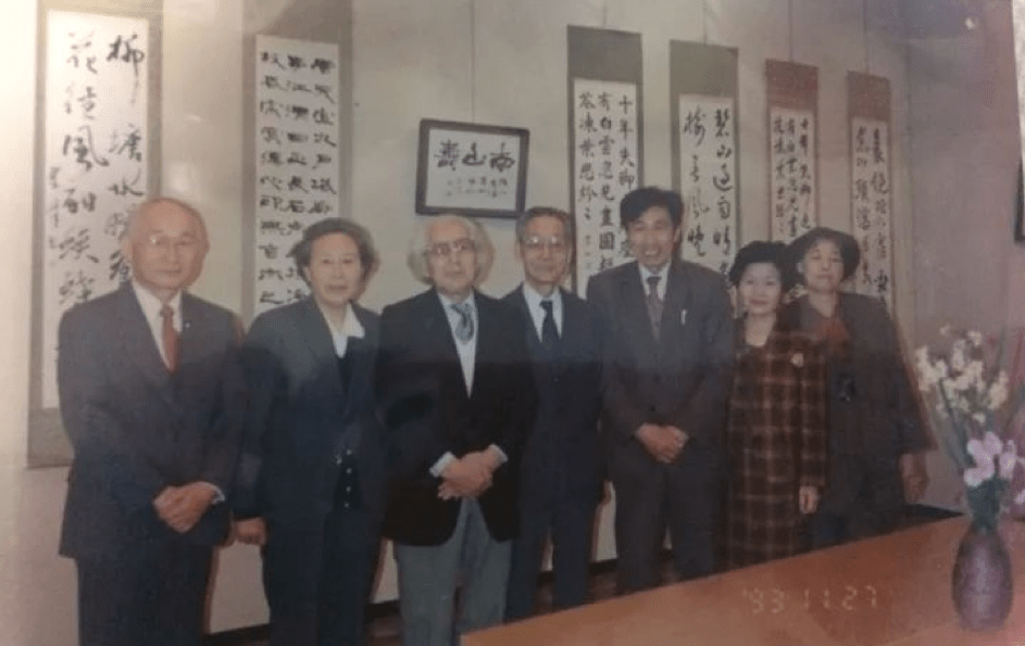 Group of seven individuals at a calligraphy exhibit
