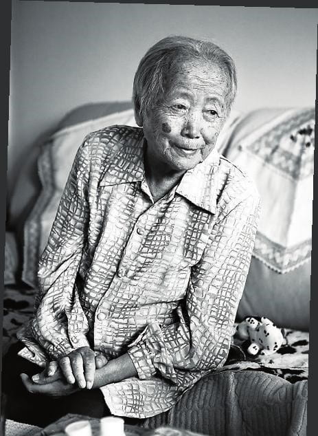 Black and white photograph of an elderly woman smiling