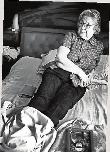 black and white of an elderly woman lying down on a bed