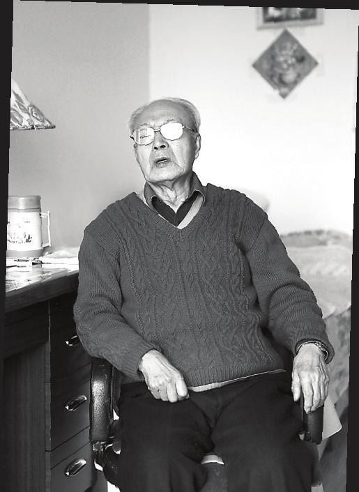 black and white photograph of an elderly Zhang Lie sitting down in his room